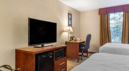 a hotel room with a television and a desk with a bed at Comfort Inn Foxboro - Mansfield in Foxborough