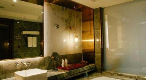 a bathroom with a sink and a shower and a toilet at Grand Metropark Hotel Chongqing in Chongqing