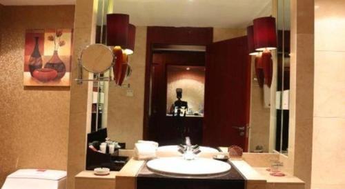 a bathroom with a sink and a mirror at Dunhuang Grand Soluxe Hotel in Dunhuang
