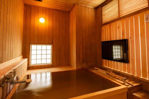 a large room with a large tub in a wooden room at LiVEMAX Resort Izu Okawa in Higashiizu