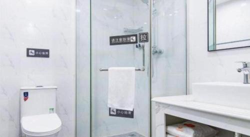 a bathroom with a toilet and a sink and a shower at 7 Days Inn Tianjin Development Zone 3rd Street Wanli in Binhai