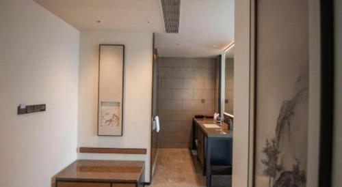 a bathroom with a sink and a vanity and a mirror at Dajiuhua Hotel in Chizhou