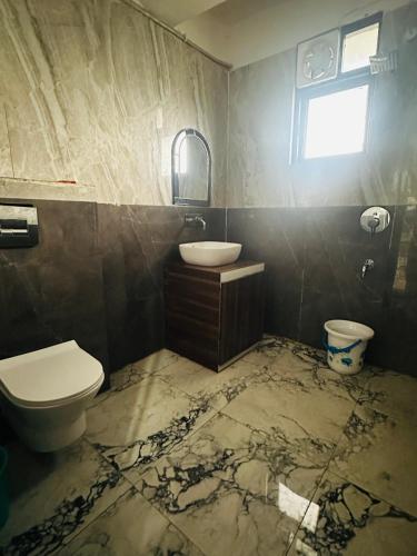 a bathroom with a toilet and a sink at Blue Homestays Rishikesh in Rishīkesh