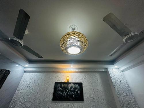 a ceiling with a chandelier and a picture on a wall at Blue Homestays Rishikesh in Rishīkesh