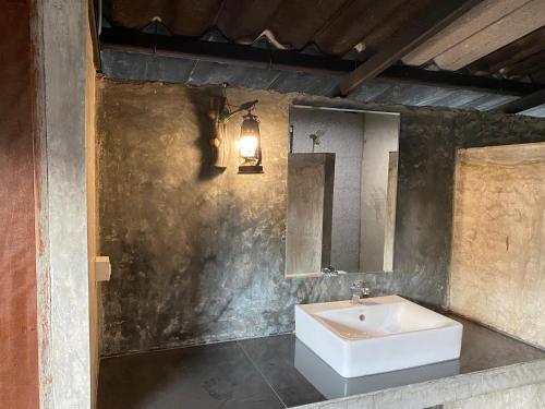 a bathroom with a white sink and a mirror at Baan Khoyee Boutique บ้านโกยีบูทีค 