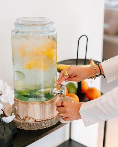 a woman is mixing a drink in a jar at The Liman Hotel in Brussels