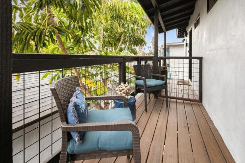 a balcony with wicker chairs on a wooden deck at Modern 1 BR Beach Waves and Sunshine in San Diego