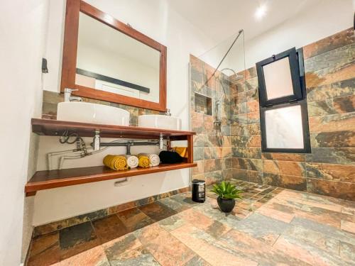 a bathroom with two sinks and a mirror at La Ŵilla, piscine et parking privatisées, accès mer, sentiers et volcans!! in Saint-Joseph