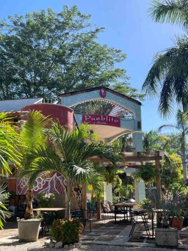 a building with a restaurant with palm trees and tables at Marina Loft in Coco