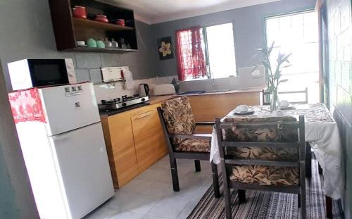 une cuisine avec une table et un réfrigérateur blanc dans l'établissement Accommodation AirB&B Fiji, à Nadi