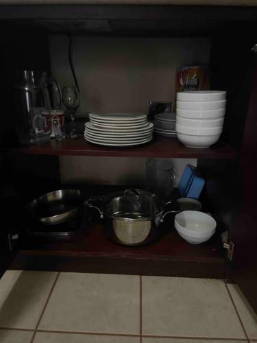 a kitchen shelf with dishes and bowls and plates at Marina Loft in Coco