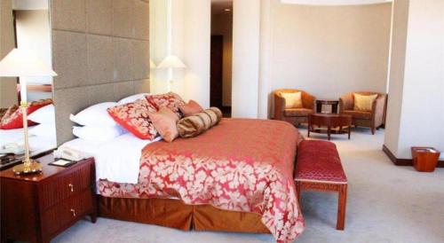 a bedroom with a bed with pillows on it at Kai Wah Plaza International Hotel in Kunming