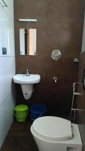 a bathroom with a white toilet and a sink at Nelleri Residency Managed By Vaishno Hospitality in Iritti