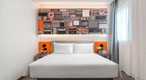 a bedroom with a white bed and a collage of records at ibis Dongguan Dongcheng in Dongguan
