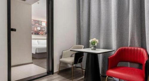 a room with a table and chairs and a mirror at ibis Dongguan Dongcheng in Dongguan