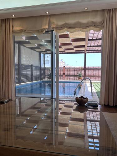 a swimming pool in a house with a glass door at Rafina Splendor in Rafina
