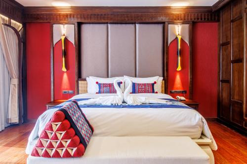 a bedroom with a large bed with red walls at S48 River Ping in Chiang Mai
