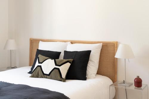 a bedroom with a bed with black and white pillows at L'Escapade Carnot - Nancy centre Stanislas - 2Pers in Nancy