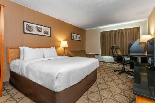 a hotel room with a large bed and a desk at Comfort Inn South in Winnipeg