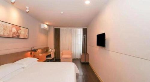 a hotel room with a bed and a television at Jinjiang Inn Select Shanghai International Tourism and Resorts Zone Chuansha Road Subway Station in Shanghai