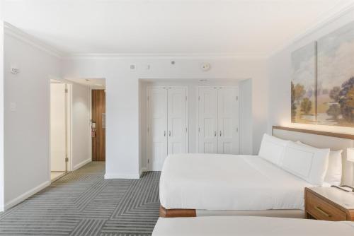 a white bedroom with a bed and a desk at Capital Hilton in Washington