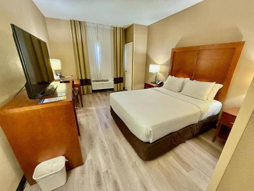 a hotel room with a bed and a flat screen tv at Comfort Inn Gurnee near Six Flags in Gurnee