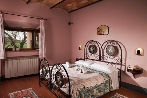 sypialnia z łóżkiem z kutego żelaza i oknem w obiekcie casella tarugi w mieście Pienza