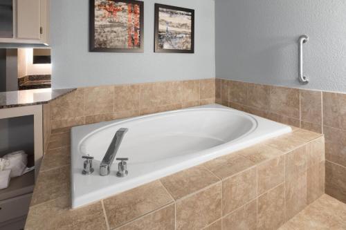 a bath tub in a bathroom with at AmericInn by Wyndham Chippewa Falls in Chippewa Falls