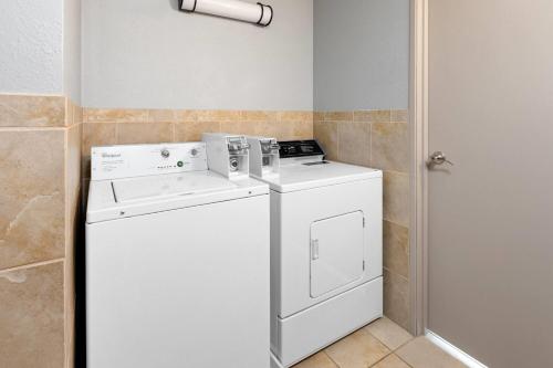 a white washer and dryer in a bathroom at AmericInn by Wyndham Chippewa Falls in Chippewa Falls