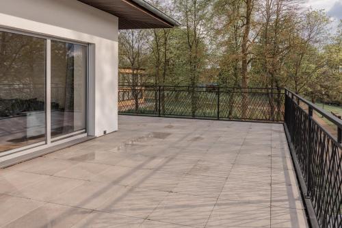 a patio with a black fence and a balcony at Echo jeziora in Charzykowy
