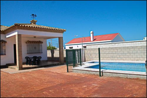 una casa con valla y piscina en Chalet Arroyo Majadales 107, en Conil de la Frontera