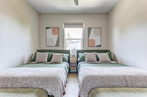 two twin beds in a room with a couch at Chic & Spacious 4 Bedroom 3 Full Bathrooms Retreat in West Tampa and Pvt Backyard in Tampa