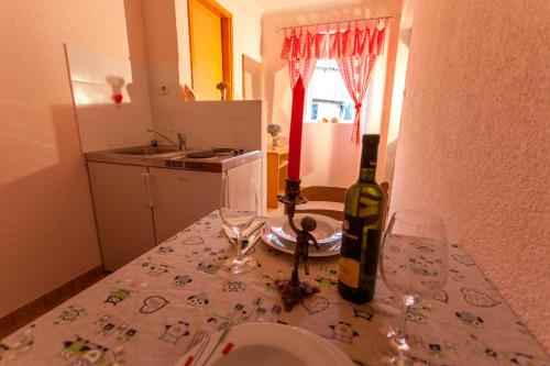 a bottle of wine and two glasses on a table at Guest House Floreus Cres in Cres