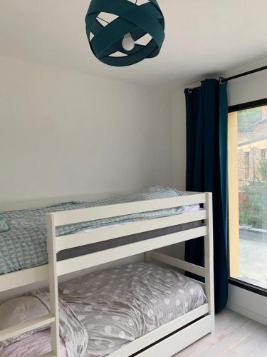 - une chambre avec des lits superposés et un lustre dans l'établissement Bright house 10m from Paris, à Sèvres