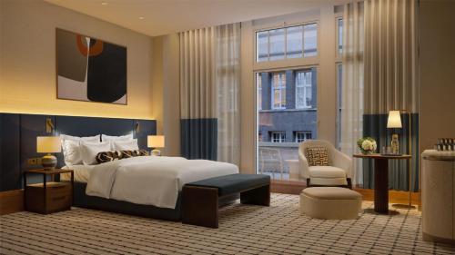 a bedroom with a king sized bed and a chair at Conrad Hamburg in Hamburg