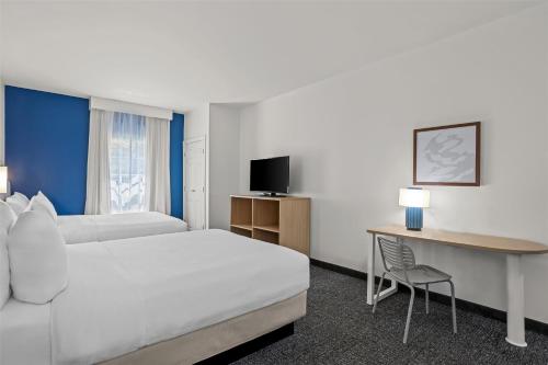 a hotel room with a bed and a desk with a computer at Spark by Hilton Bluffton Hilton Head Island in Bluffton