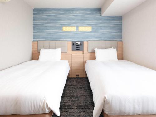 a room with two beds and a painting on the wall at Comfort Hotel Tokyo Kiyosumi Shirakawa in Tokyo