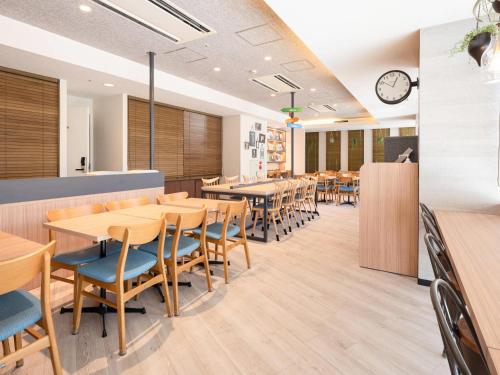 a restaurant with wooden tables and chairs and a clock at Comfort Hotel Tokyo Kiyosumi Shirakawa in Tokyo