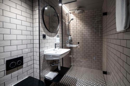 a white bathroom with a sink and a mirror at Scandic Norreport in Copenhagen