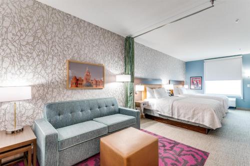 a hotel room with a bed and a couch at Home2 Suites By Hilton Dallas Medical District Lovefield, Tx in Dallas