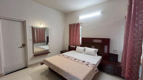 a small bedroom with a bed and a mirror at Manjul Bungalow in Nashik
