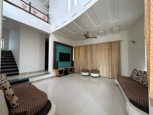 a living room with a couch and a television at Manjul Bungalow in Nashik