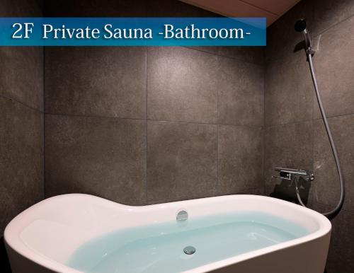 a bath tub in a bathroom with the words private sauna bathroom at SAUNA&HOTEL Suuh スゥ in Takahagi