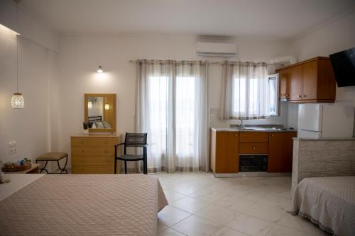 a bedroom with a bed and a kitchen with a sink at Sunrise Studios in Megalochori