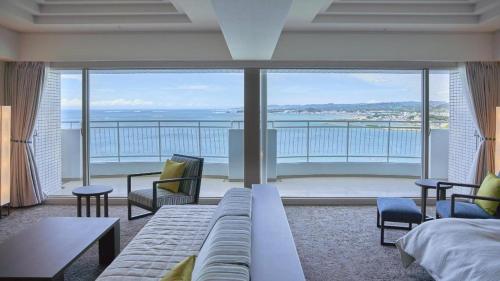 a living room with a couch and a view of the ocean at Hotel Harvest Nankitanabe in Tanabe