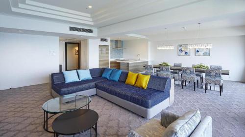 a living room with a blue couch and a table at Hotel Harvest Nankitanabe in Tanabe