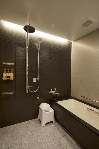 a bathroom with a tub and a toilet and a shower at Hotel Harvest Nankitanabe in Tanabe