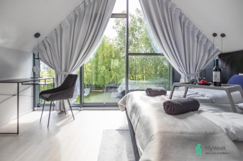 a bedroom with two beds and a large window at Dom w Starkowie, Basen i Sauna 