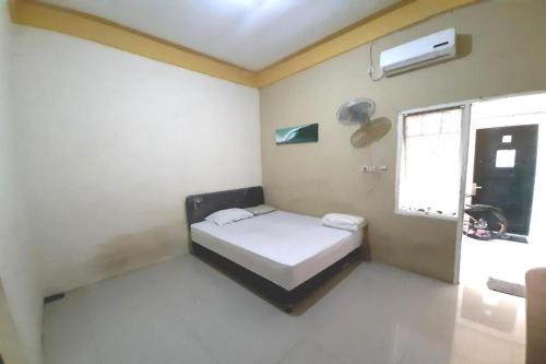 a small room with a bed and a window at OYO Life 2982 Griya Aisyah Residence 2 in Kedurus