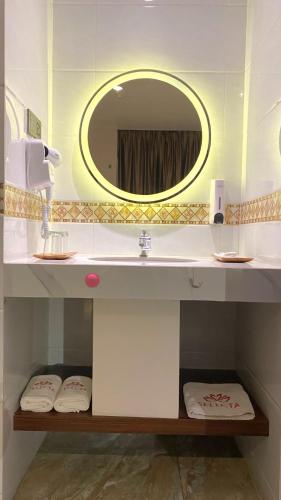 ein Badezimmer mit Waschbecken und Spiegel in der Unterkunft SELECTA HOTEL Medan in Medan